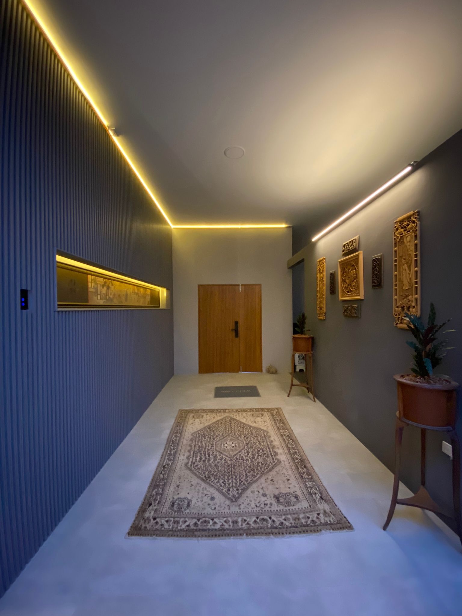 Villa Koh entrance corridor with LED cove lighting and carved art wall