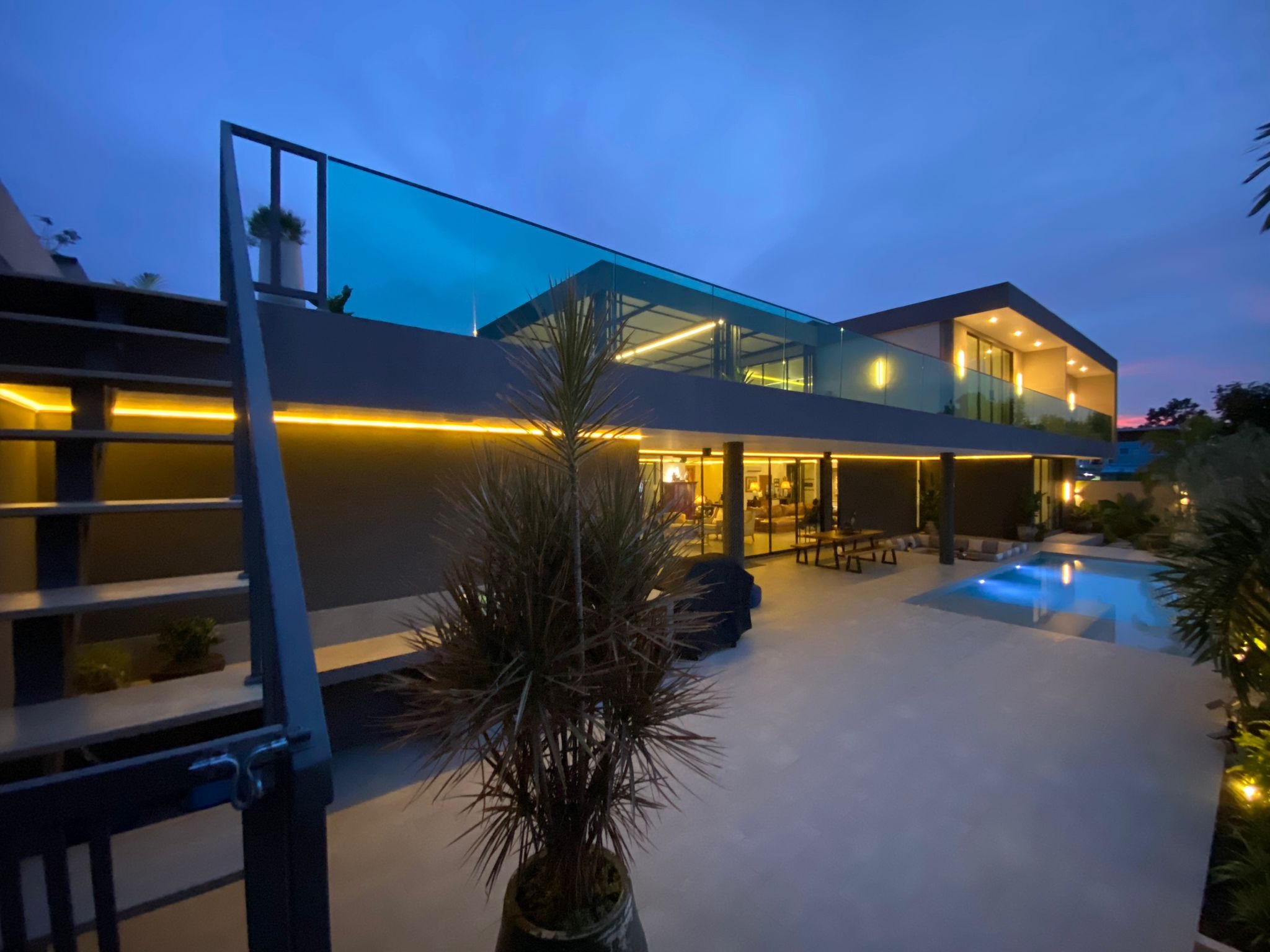 Villa Koh illuminated at dusk with pool and two-storey facade