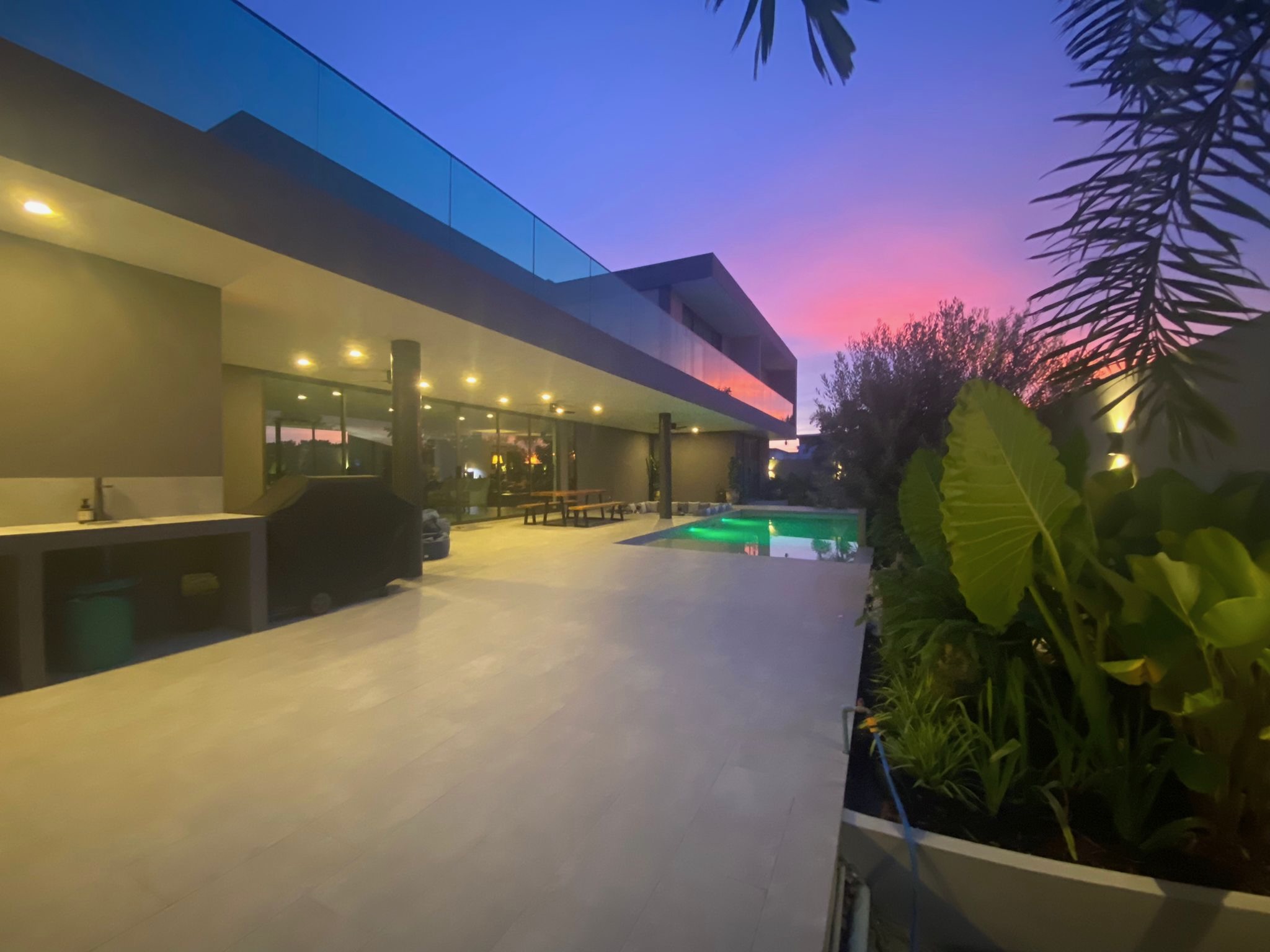 Villa Koh exterior at pink and purple sunset with tropical garden
