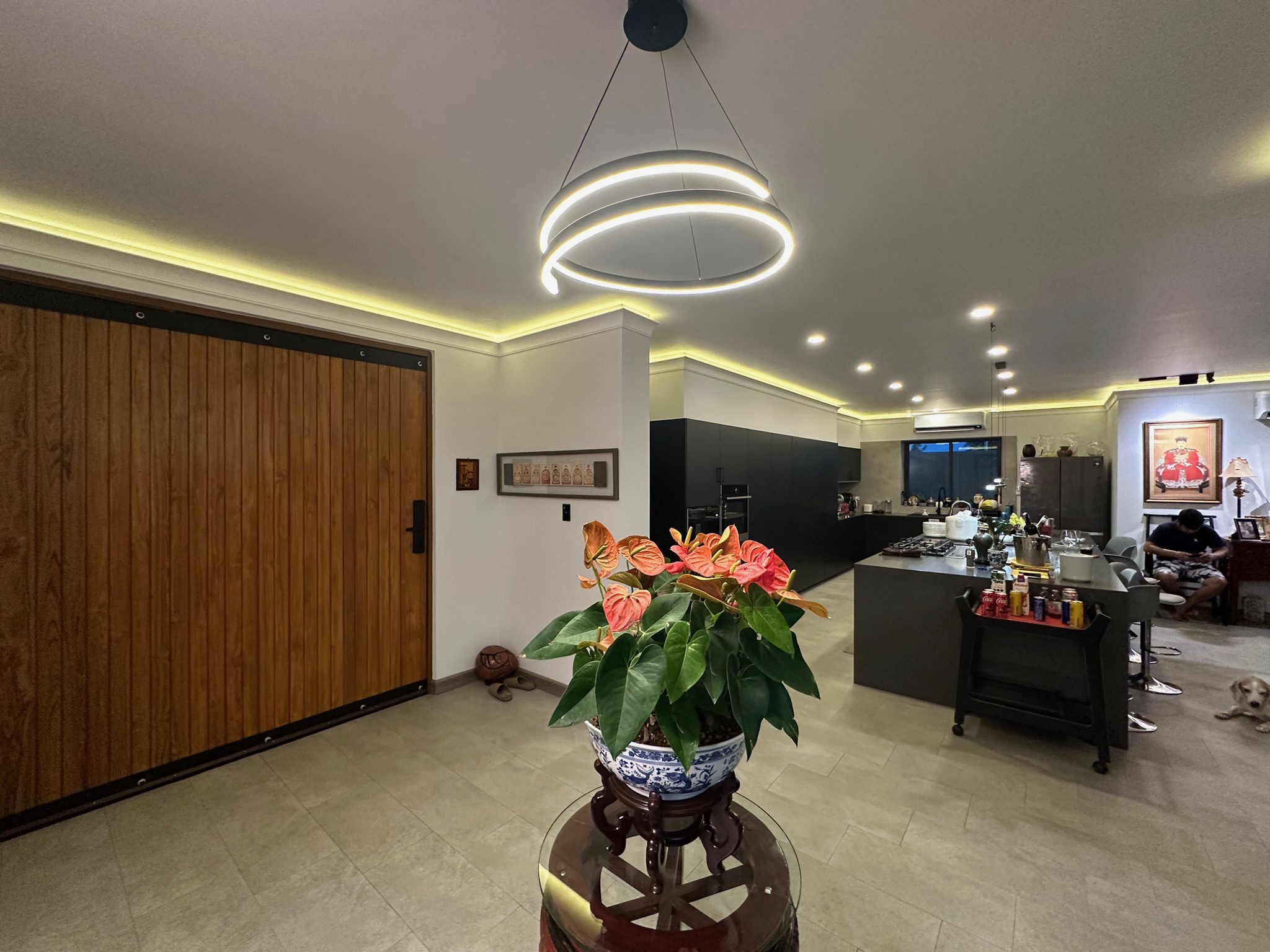 Open-plan kitchen and dining with circular pendant and sliding barn door