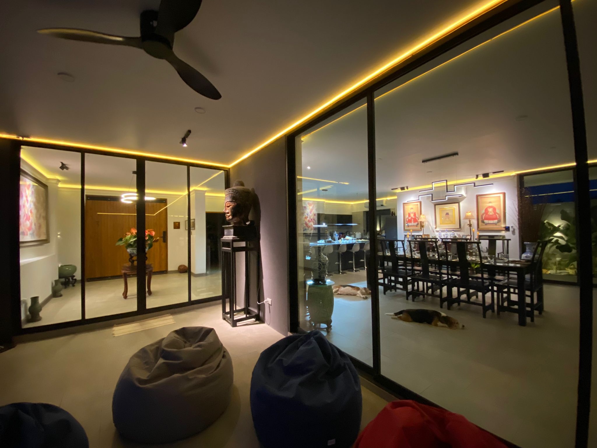 Covered terrace and living areas viewed through full-height glazing at night