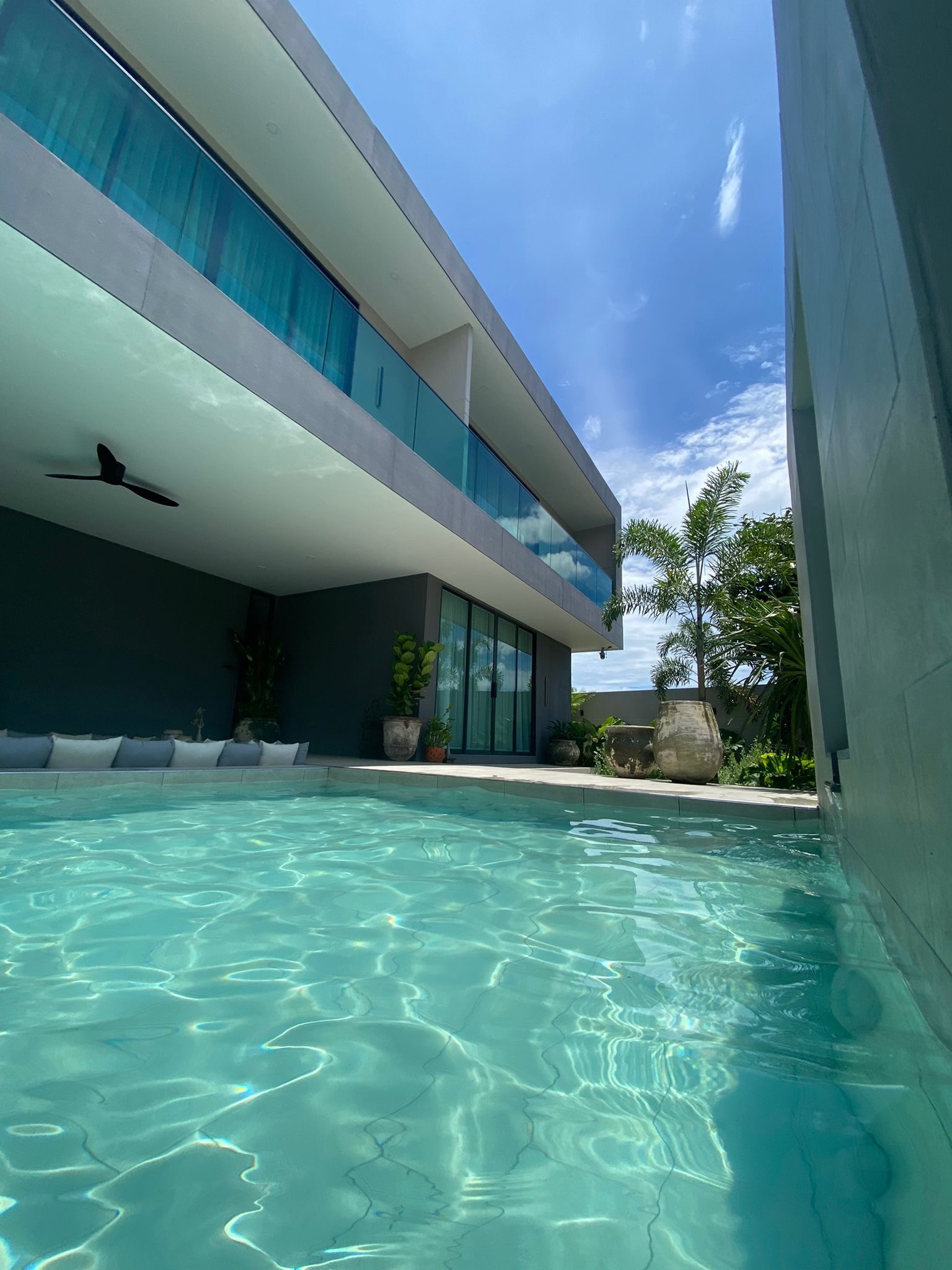 Villa Koh pool with glass balustrade and two-storey facade in daylight